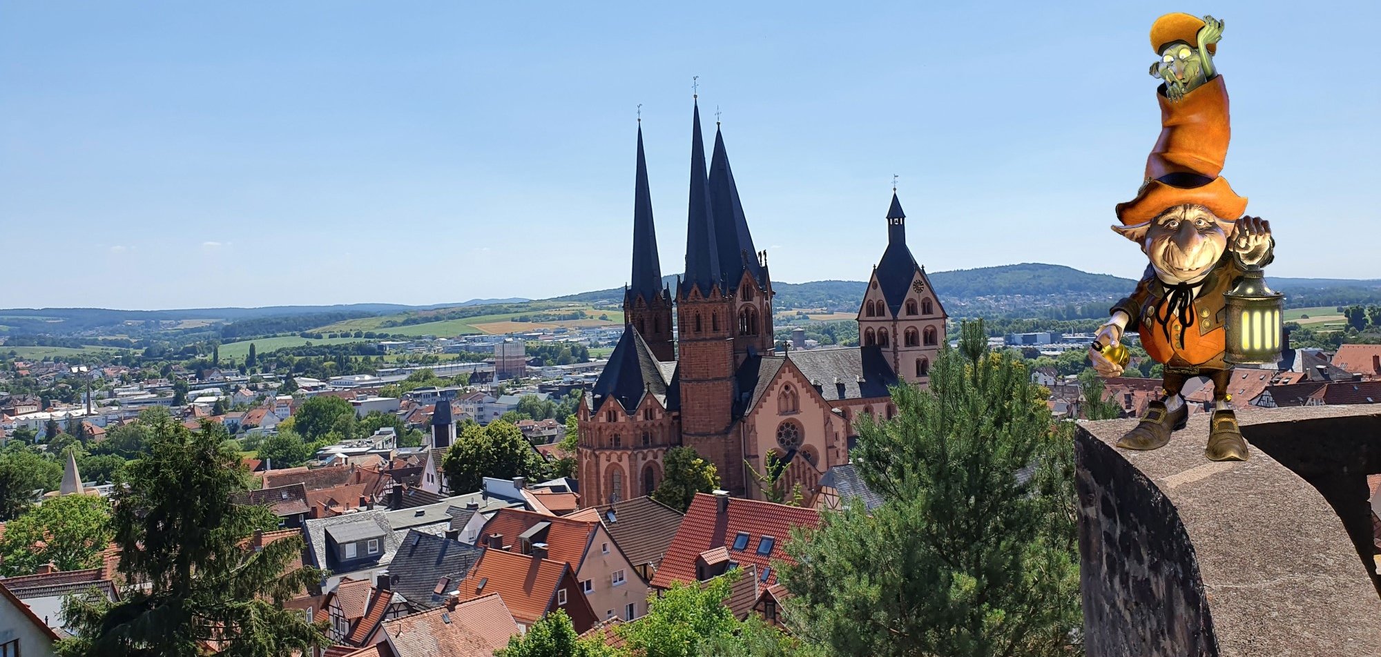 Gelnhausen retten - zum Aktionspreis Blick vom Halbmond aus auf die Stadt und die Marienkirche. Auf dem rechten Halbkreis des Turmes balanciert der Kobold mit seiner Laterne. Es handelt sich um eine Bildmontage.
