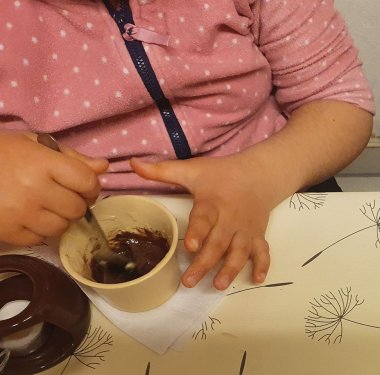 Schokoprojekt in der Kita Rappelkiste: Ein Kind rührt Schokolade in einer Tasse.