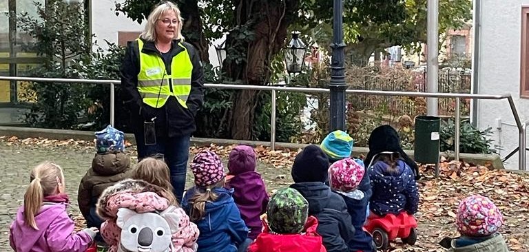 Kinder sitzen im Museumshof auf Bobbycars.
