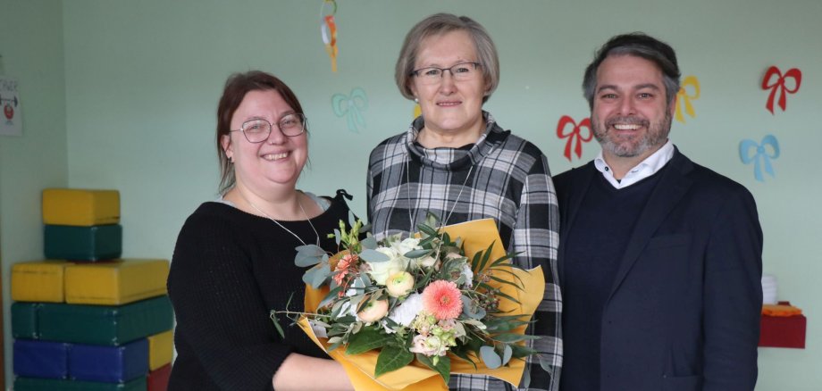 Frau Smolka mit Blumen, Kita-Leitung und Bürgermeister.