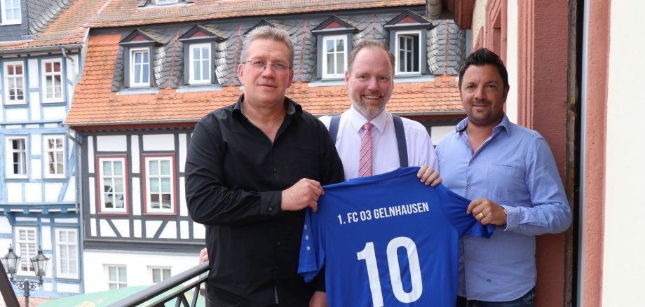 Der Vorstand des Fußballclubs überreicht Christian Litzinger ein Trikot mit der Rückennummer 10.