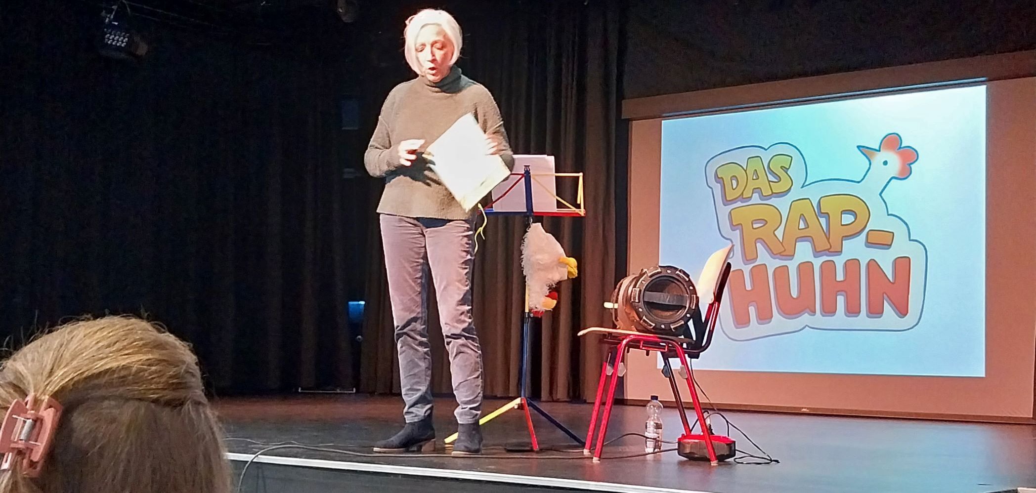 Die Künstlerin mit Utensilien auf der Bühne.