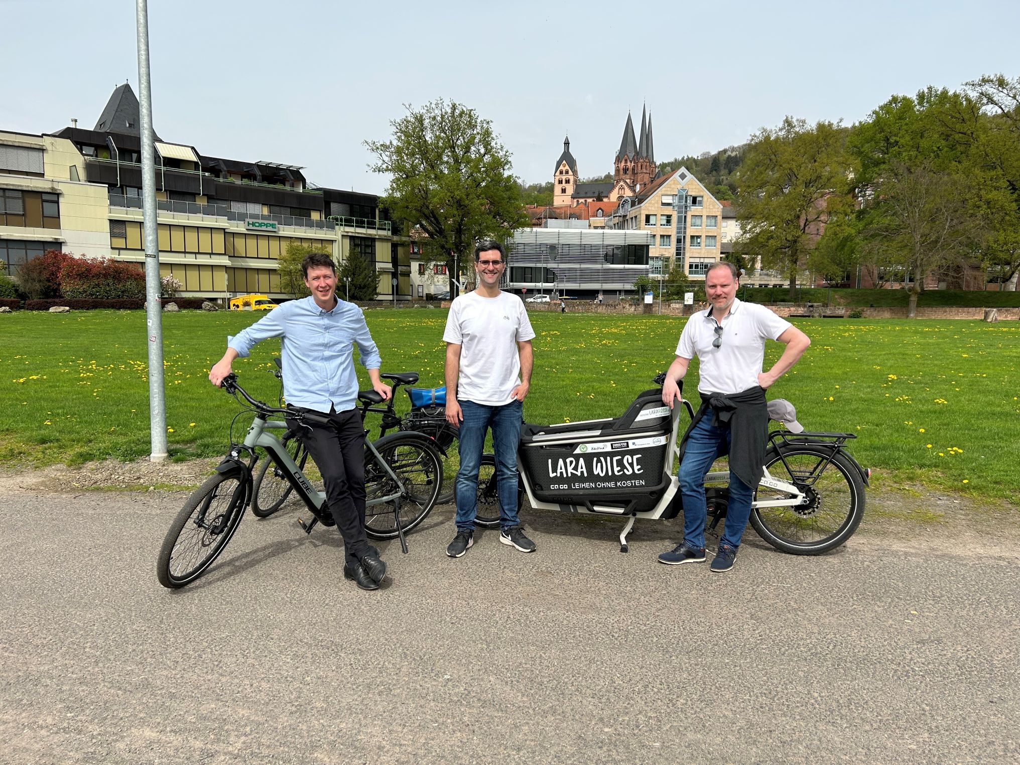Bürgermeister, Bauamtsleiter und Klimamanager mit einem Leihlastenfahrrad auf der Müllerwiese.