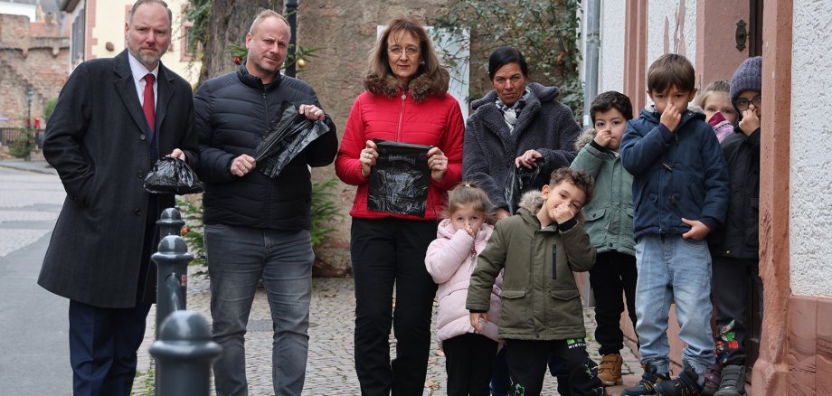 Hundekot vor der Kita Gruppenbild mit dem Bürgermeister vor dem Kita-Eingang. Der Hundehaufen ist abgedeckt.