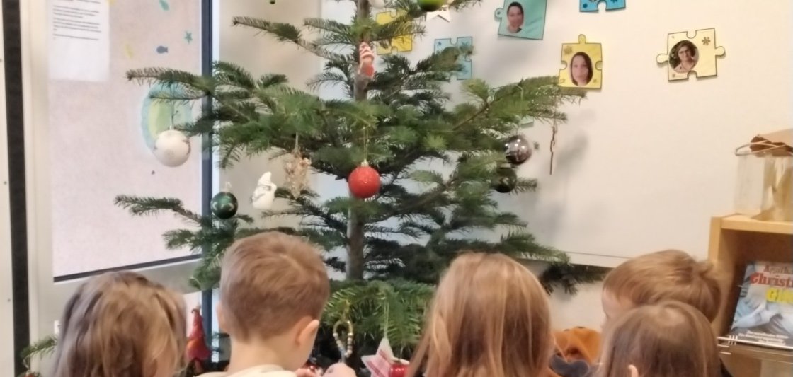 Kinder schmücken einen Weihnachtsbaum.