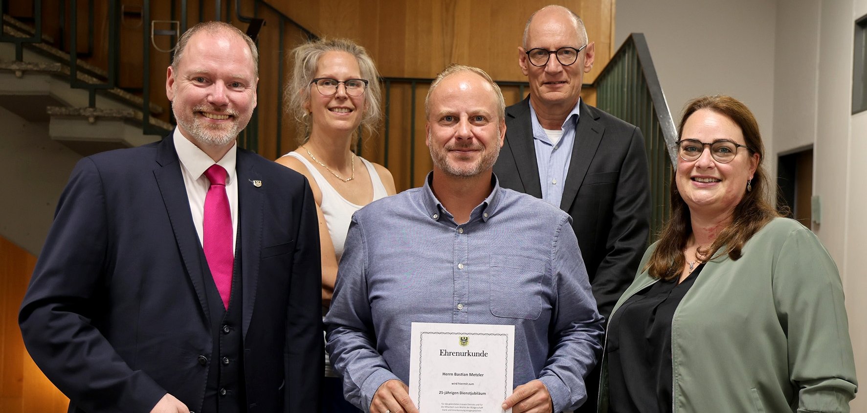 Dienstjubiläum Bastian Metzler Gruppenbild mit Bürgermeister und Bastian Metzler mit Urkunde.
