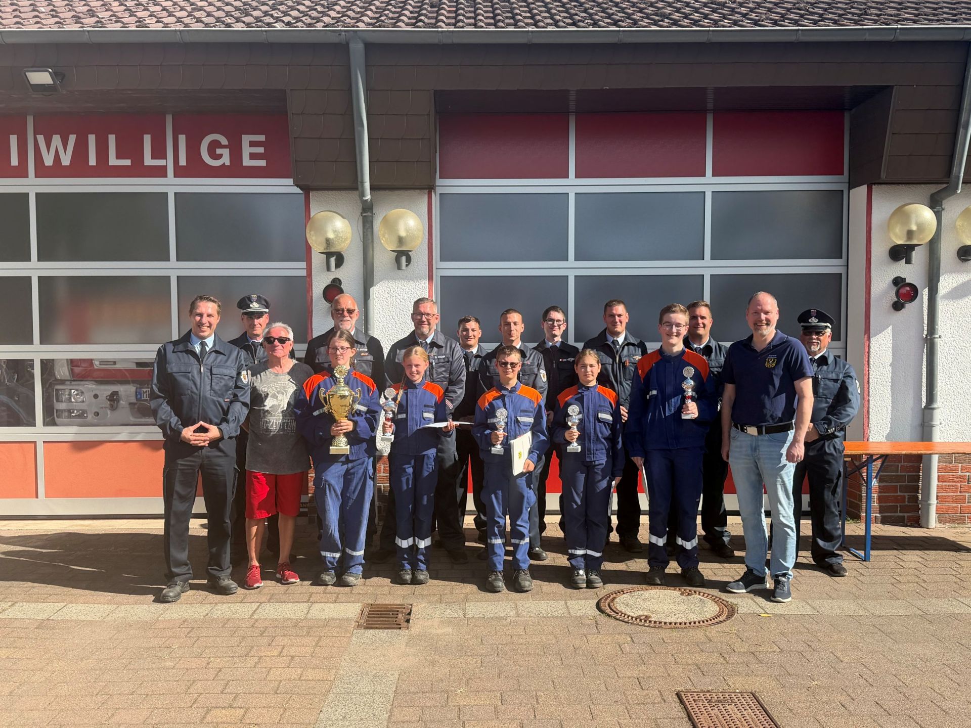 Gruppenbild der siegreichen jungen Feuerwehrleute mit dem Bürgermeister und einigen Aktiven. 