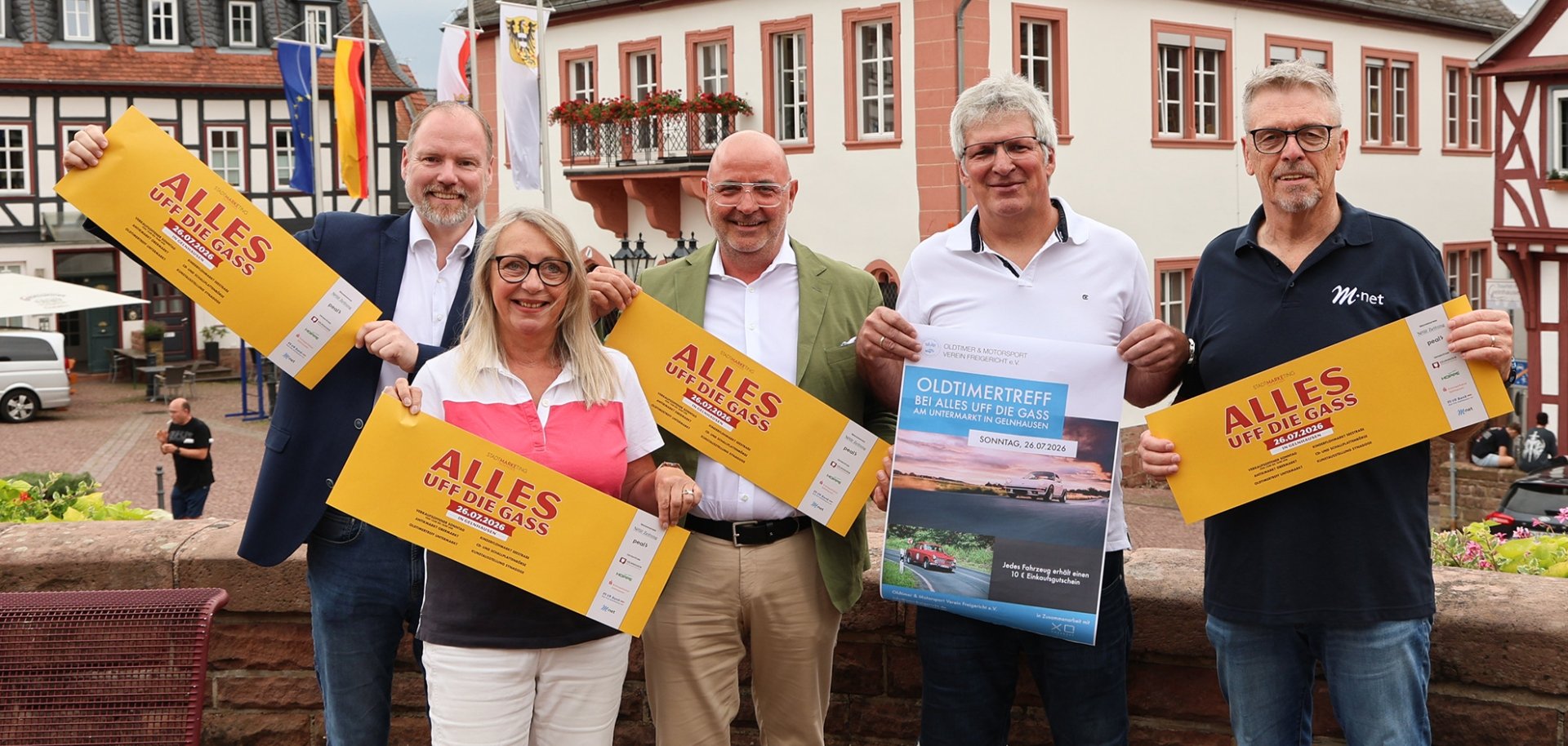Alles uff die Gass Gruppenbild mit Bürgermeister und Stadtmarketing mit Plakaten und Blick aufs Rathaus.