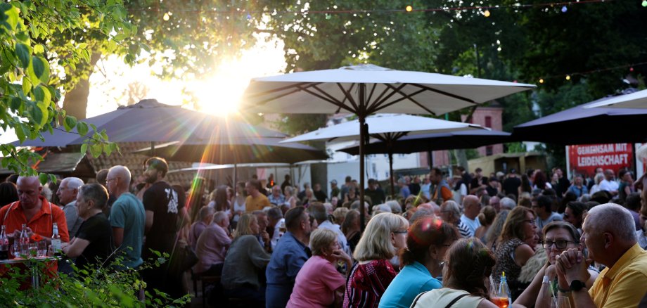 Altstadtweinfest Menschenmassen sitzen an Tischen im Stadtgarten und Essen und Trinken.