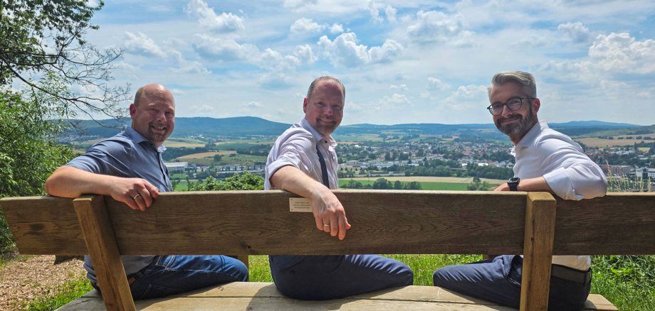 Bank Panoramaweg Der Bürgermeister und EAM-Vertreter sitzen auf der neuen Bank am Panoramaweg.