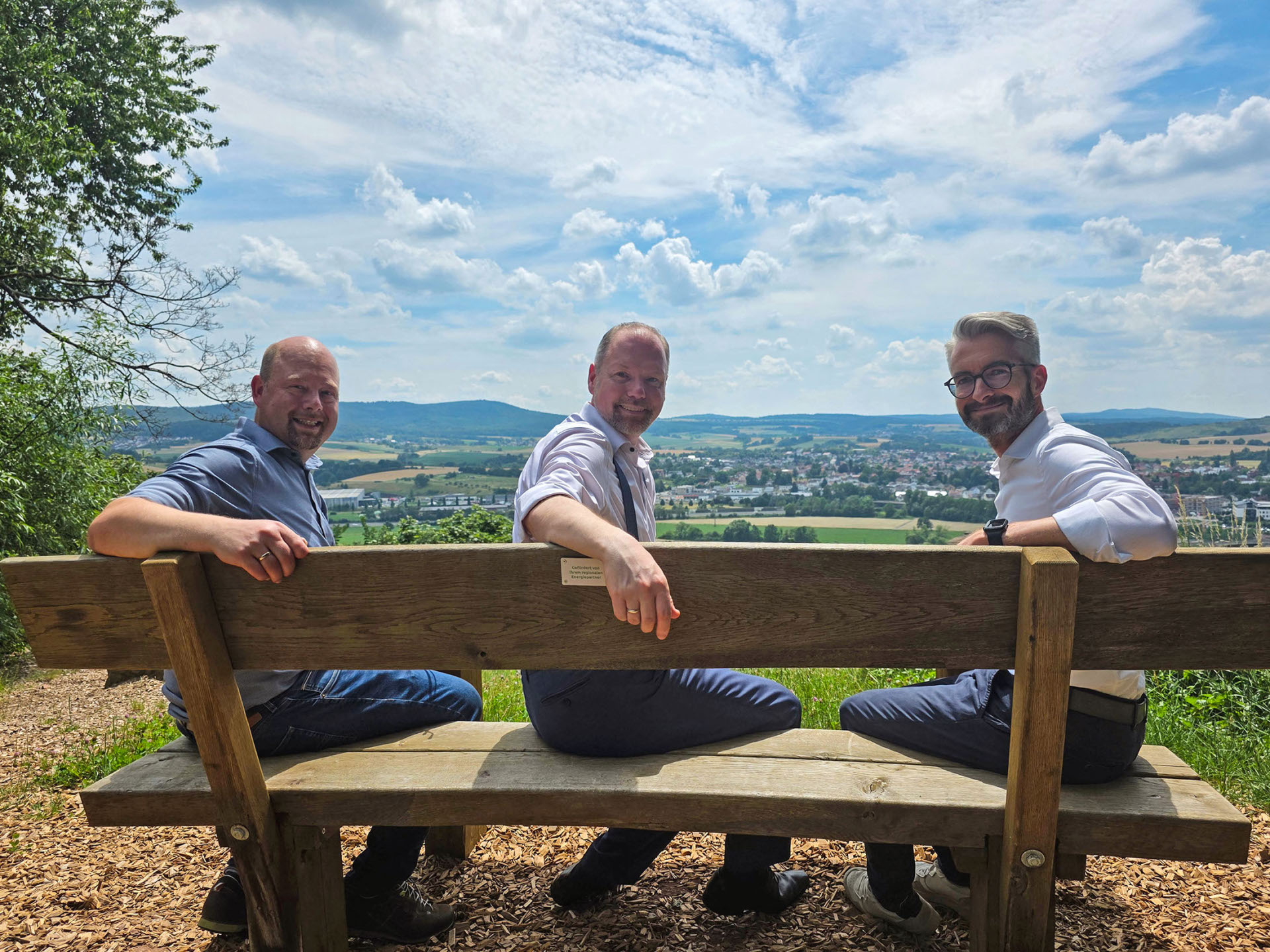 Der Bürgermeister und EAM-Vertreter sitzen auf der neuen Bank am Panoramaweg.