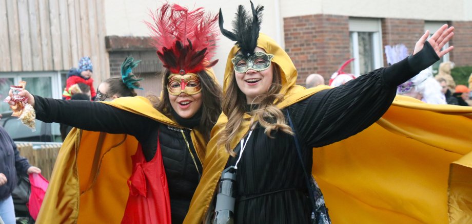 Zwei maskierte Frauen in Feierlaune.