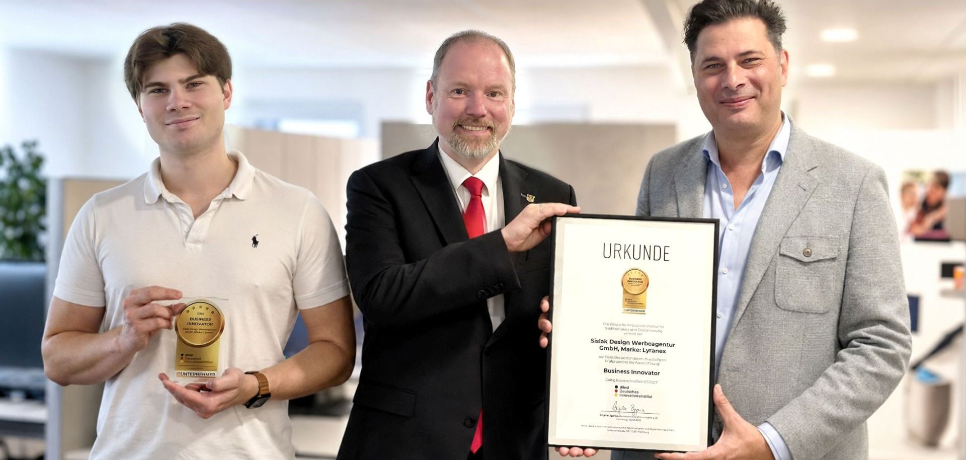 Die Chefs der Werbeagentur Sislak mit dem Bürgermeister, der Urkunde und der Trophäe.
