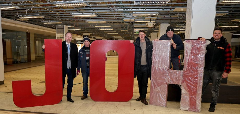 Gruppenbild mit dem Schriftzug JOH, der an der Fassade angebracht war.