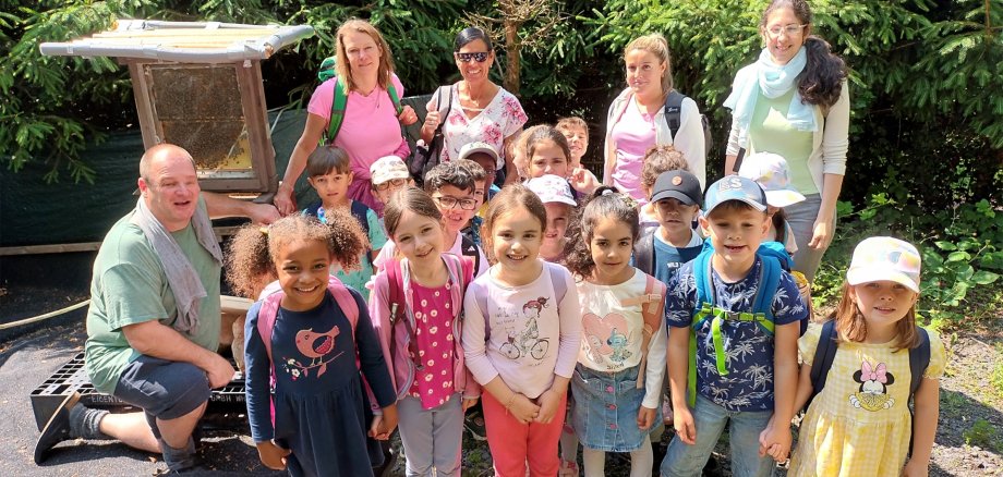 Die Kinder mit pädagogischen Fachkräften und dem Imker.