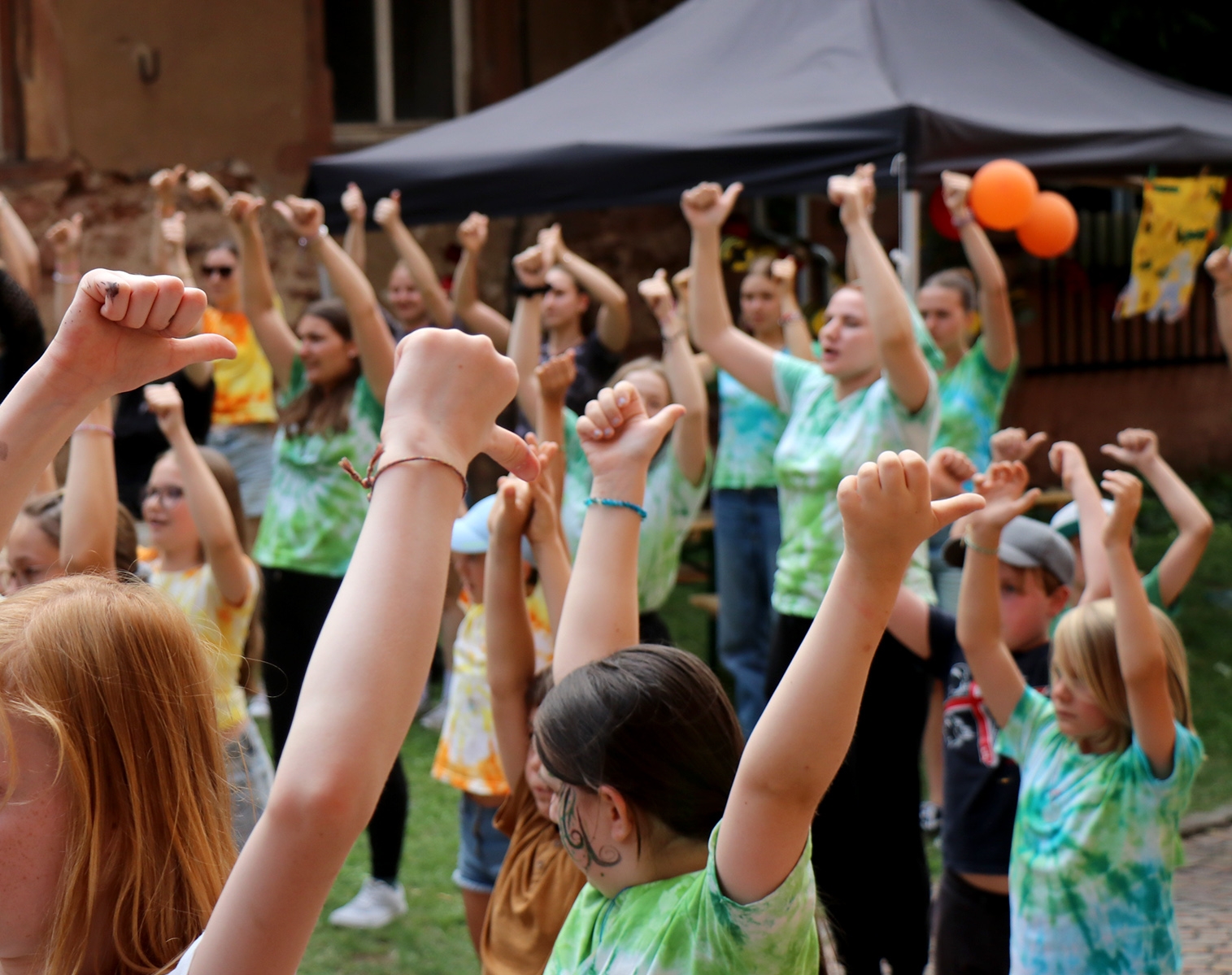 Kinder in bunten T-Shirts beim Tanzen.