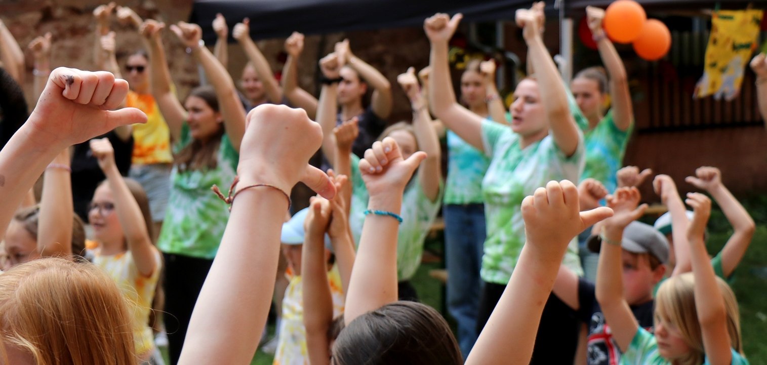 Kinder in bunten T-Shirts beim Tanzen.