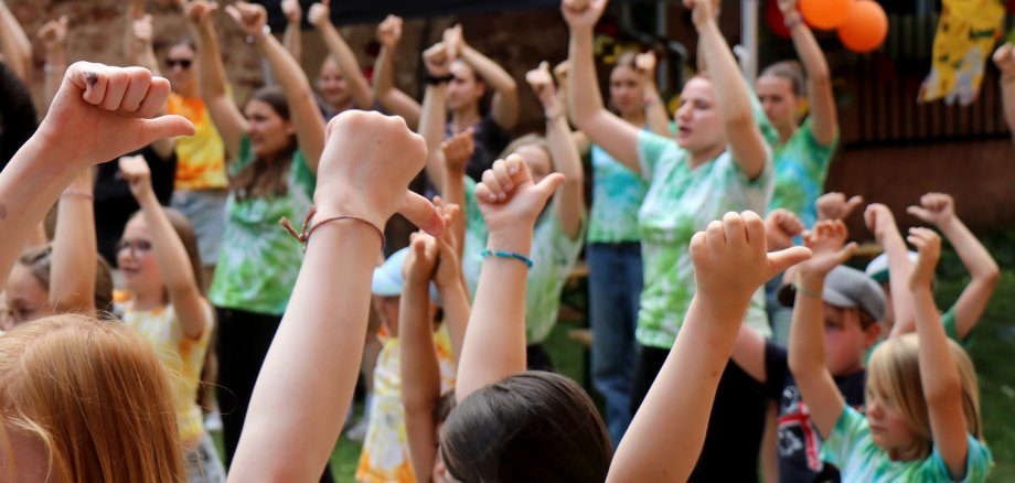 Kinder in bunten T-Shirts beim Tanzen.
