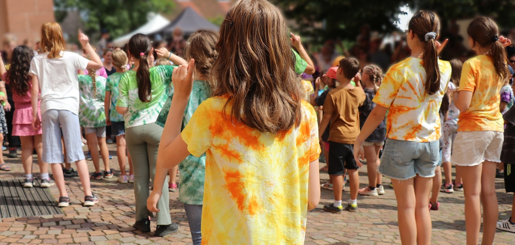 Kinder in bunten T-Shirts beim Tanzen.