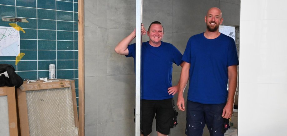 Die Badleiter Tobias Klein und Robin Schmidt in der neuen Duschanlage.