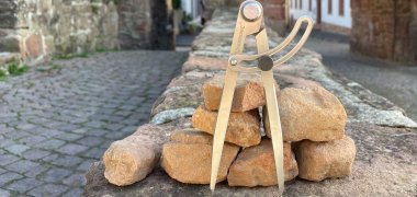 Bild des Inneren Holztores mit Steinen und einem Zirkel im Vordergrund