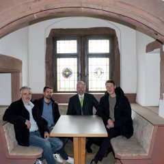 Projektplaner und Stadtvertreter sitzen an einem Tisch im Fürstenhof. Ein Flüsterbogen ist im Vordergrund zu sehen.