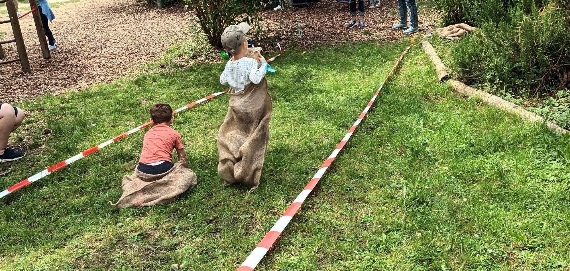 Kinder beim Sackhüpfen.