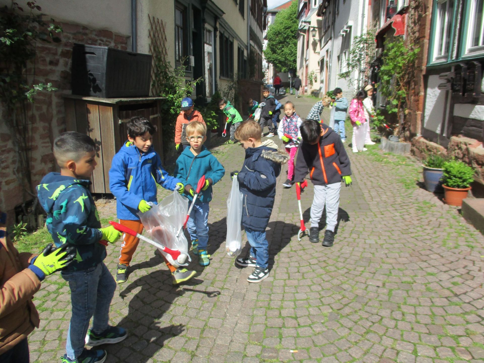 Kinder sammeln Müll in der Pfarrgasse.