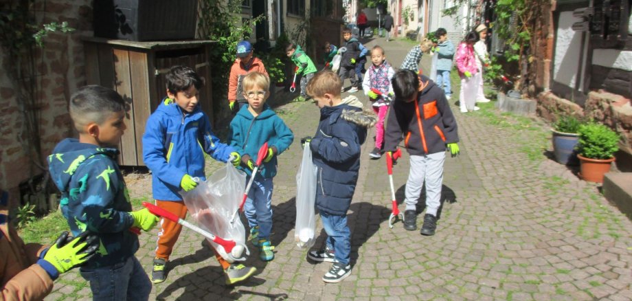 Kinder sammeln Müll in der Pfarrgasse.