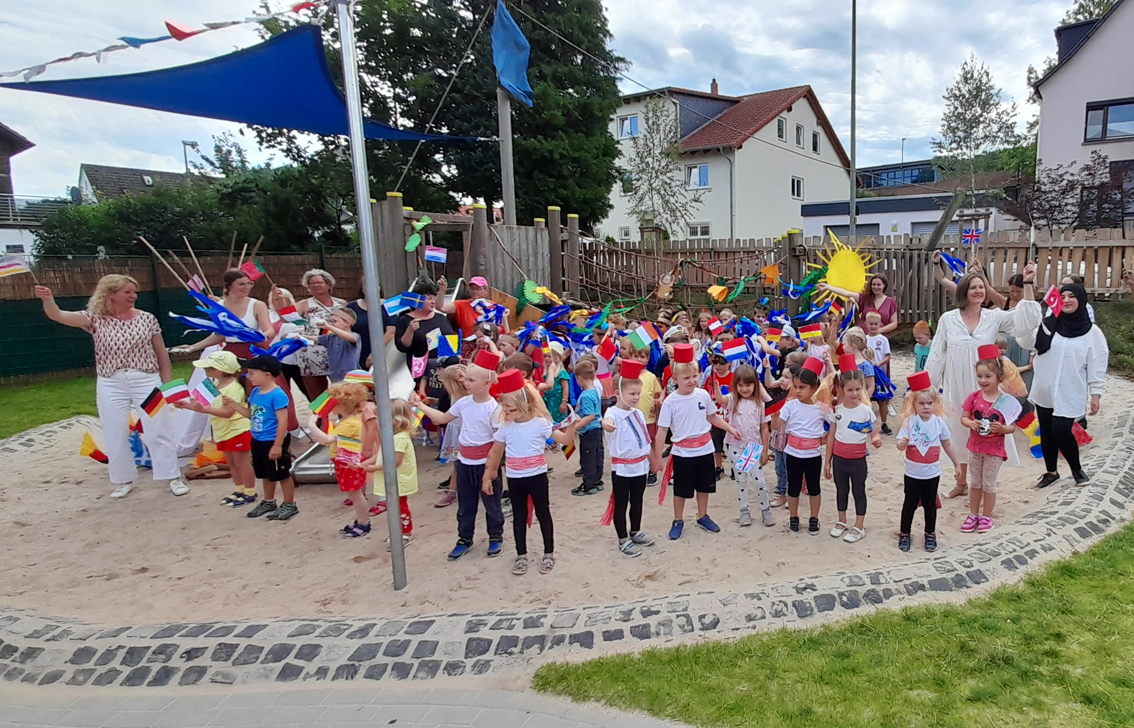 Gruppenbild mit Kindern und Fähnchen aus aller Herren Länder.