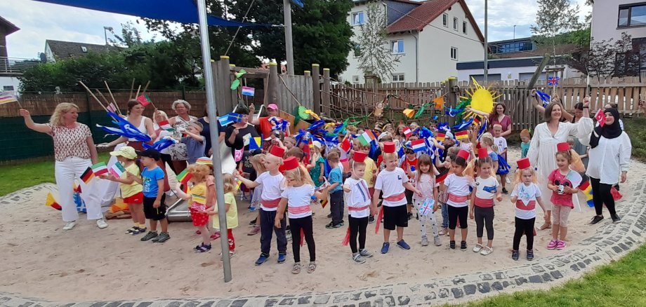 Gruppenbild mit Kindern und Fähnchen aus aller Herren Länder.