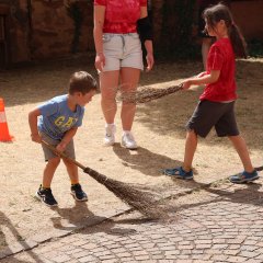 Kindersommer 2026 Ein Mädchen und ein Junge nutzen Hexenbesen für den Zweikampf.