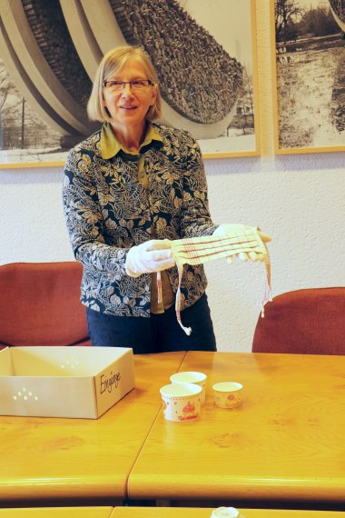 Archivleiterin Anette Vinnen zeigt eine aus einem Geschirrtuch genähte Mund-Nasen-Abdeckung. 