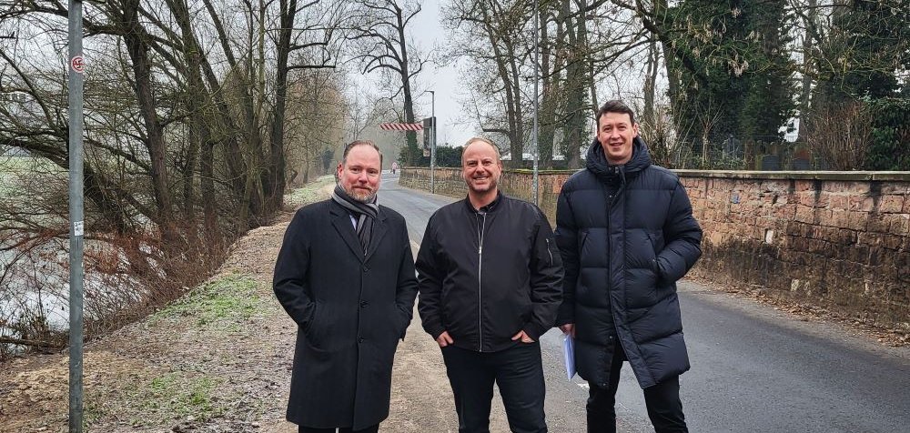 Bürgermeister Christian Litzinger, Ordnungsamtsleiter Bastian Metzler und Bauamtsleiter Eppo Haas stehen an der Einbahnstraße am Parkplatz Am Escher. 