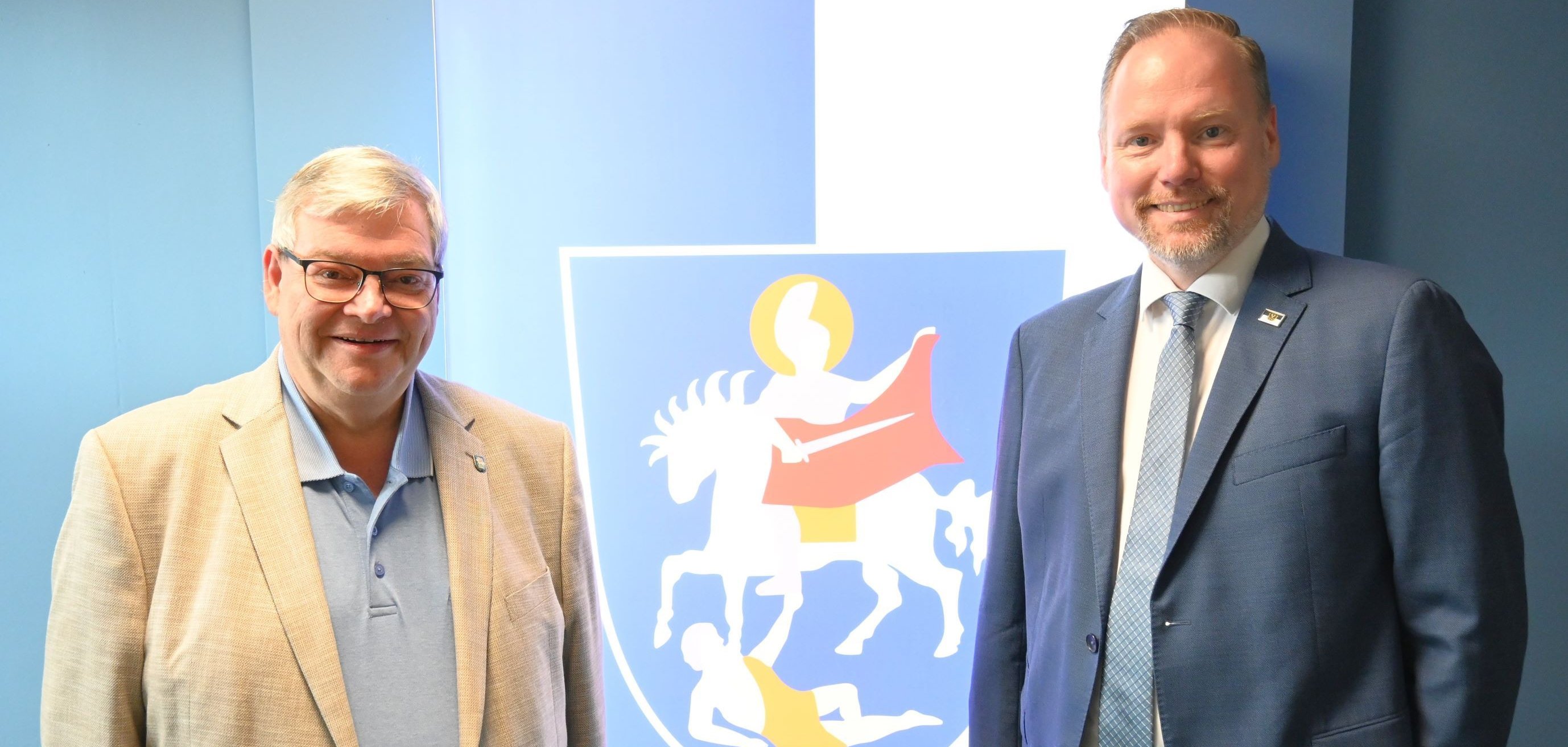 Die Bürgermeister von Gelnhausen und Bad Orb stehen vor dem Wappen der Stadt Bad Orb.