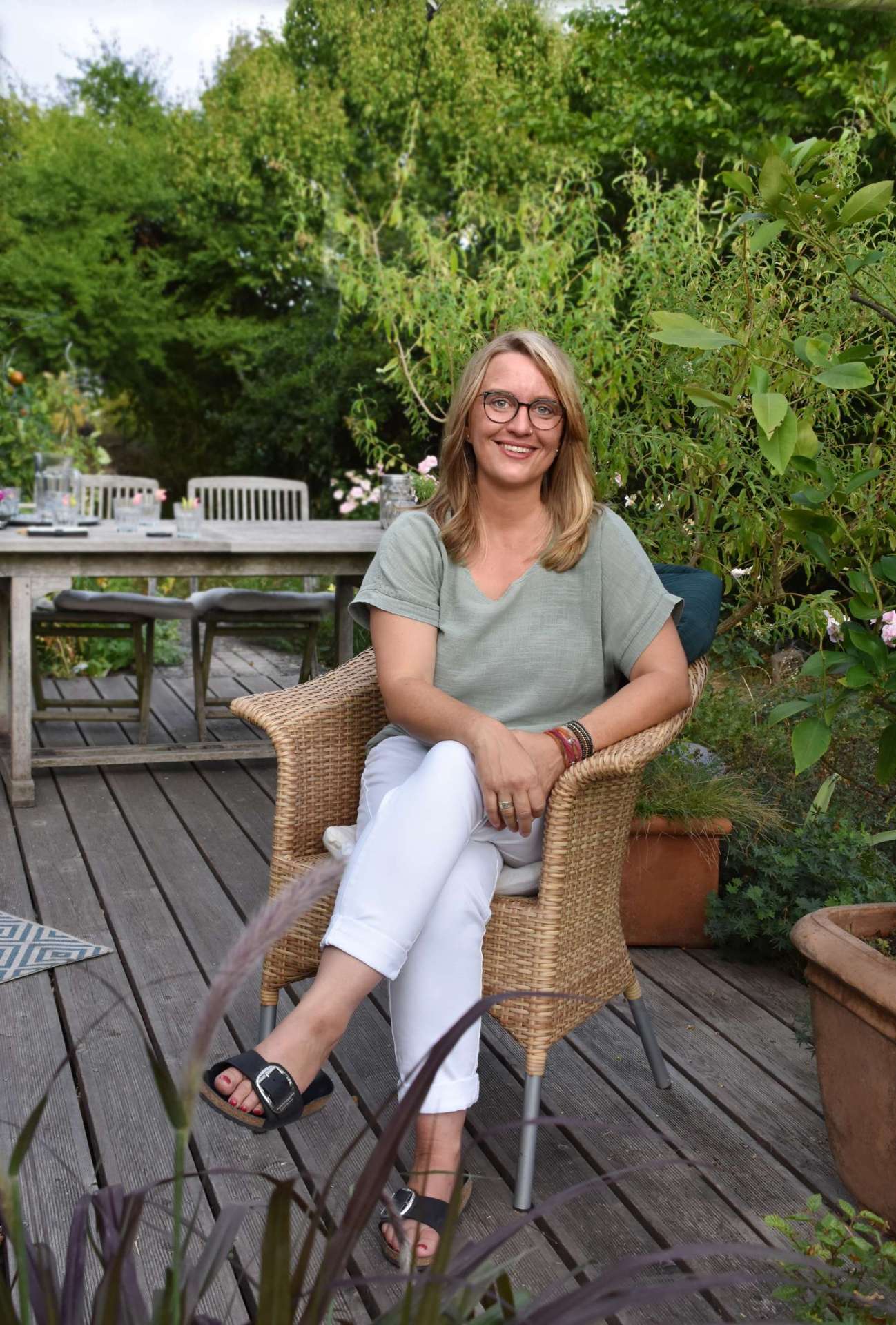 Verena Scheuermann sitzt auf einem Stuhl auf einer Terrasse.
