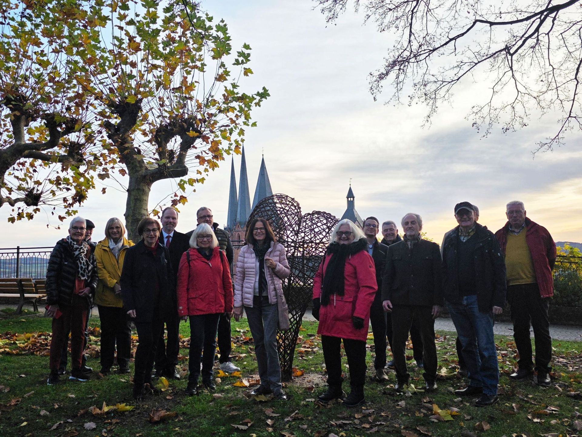 Gelnhausen - Stadt mit Herz (1) Eine Gruppe Menschen steht im Stadtgarten an der neuen Skulptur, die die Form eines Herzens hat.