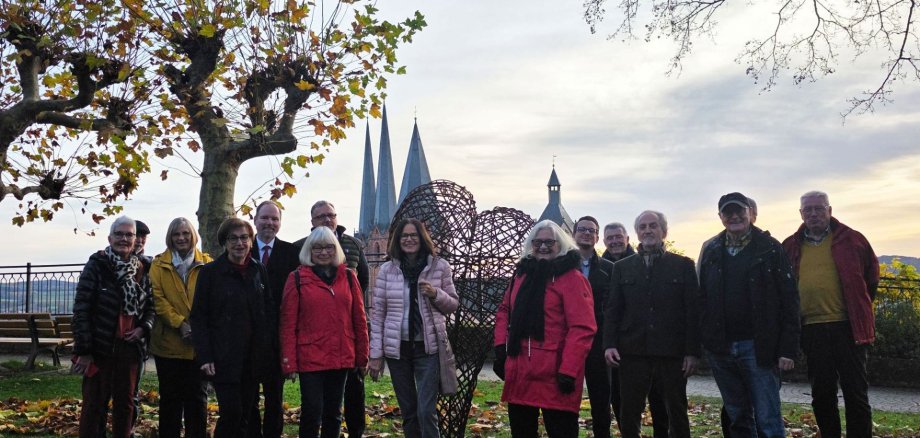 Gelnhausen - Stadt mit Herz (1) Eine Gruppe Menschen steht im Stadtgarten an der neuen Skulptur, die die Form eines Herzens hat.