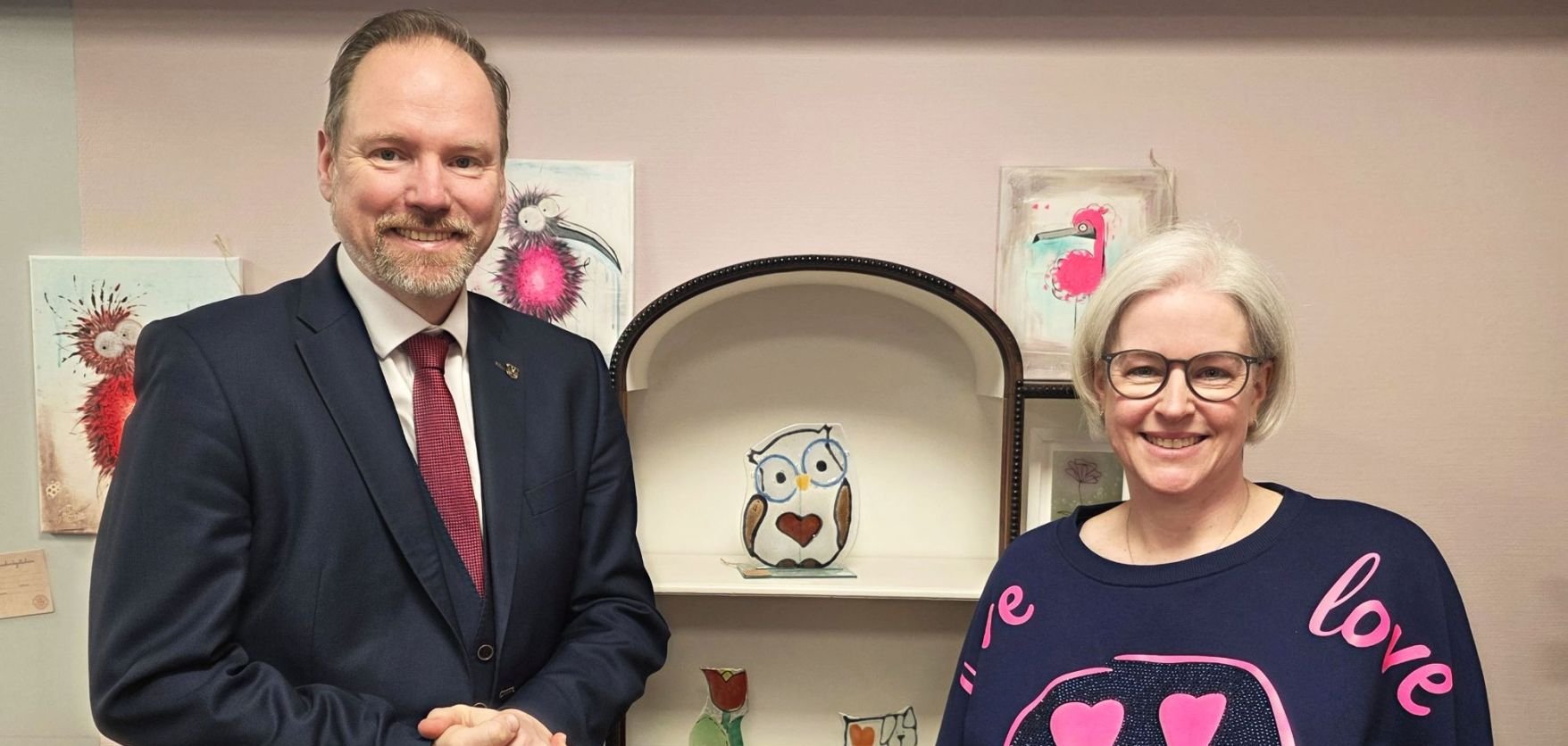 Bürgermeister Christian Litzinger (links) steht mit Geschäftsführerin Meike Kurz (rechts) in der Glaszauber-Werkstatt in der Schmidtgasse vor einem Regal mit Glaskunstwerken.  