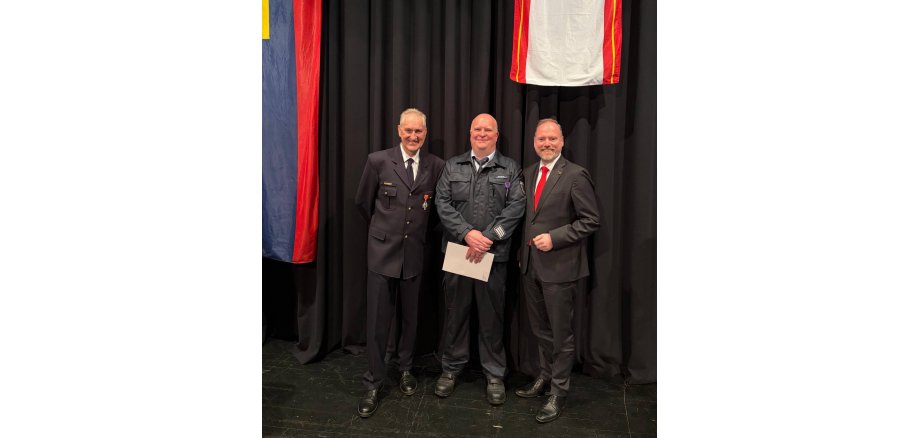 Drei Männer stehen nebeneinander: Bürgermeister Christian Litzinger rechts, Feuerwehrmann Volker Achtert links und Feuerwehrmann Martin Sperzel in der Mitte.   