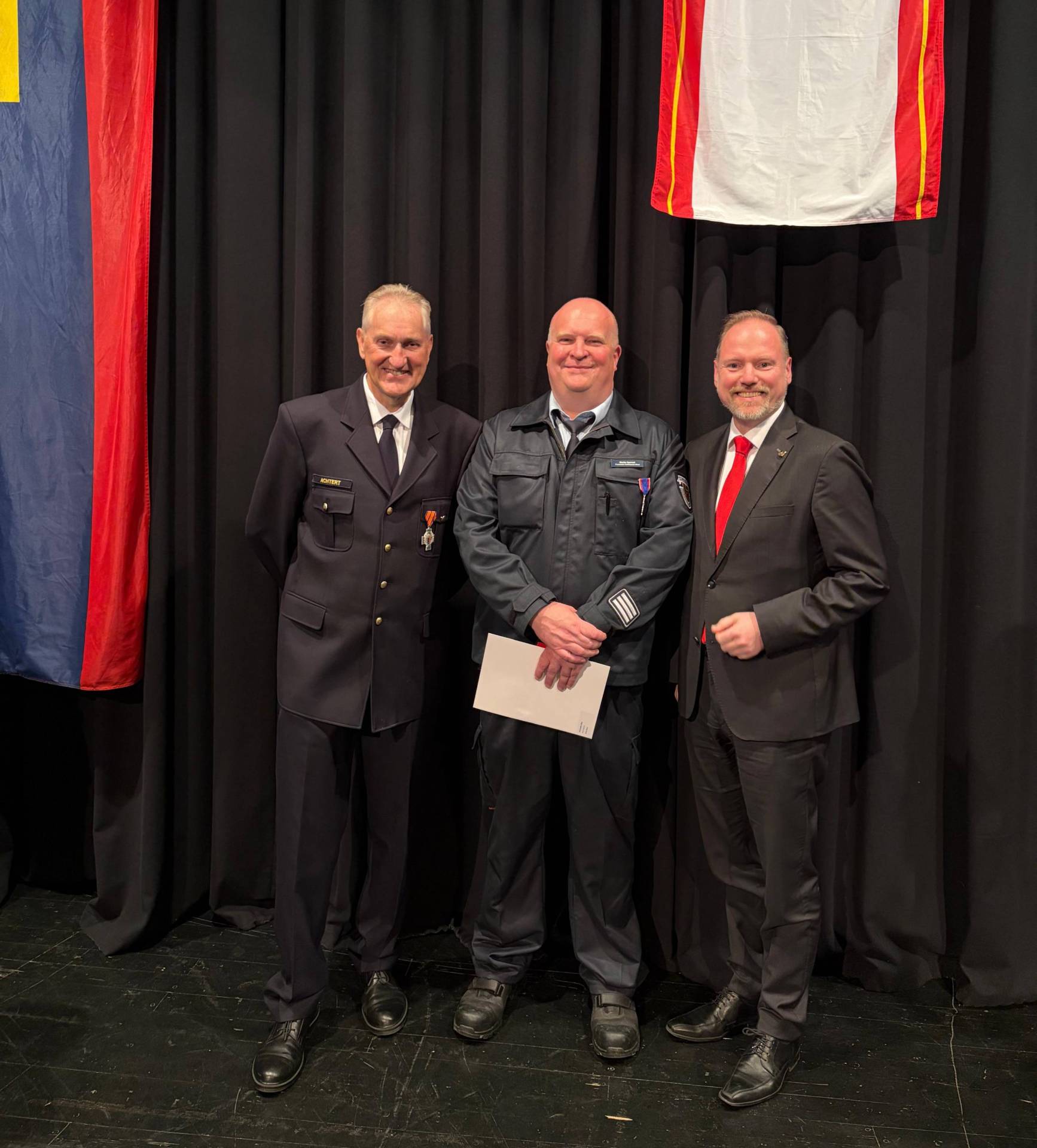Drei Männer stehen nebeneinander: Bürgermeister Christian Litzinger rechts, Feuerwehrmann Volker Achtert links und Feuerwehrmann Martin Sperzel in der Mitte.   