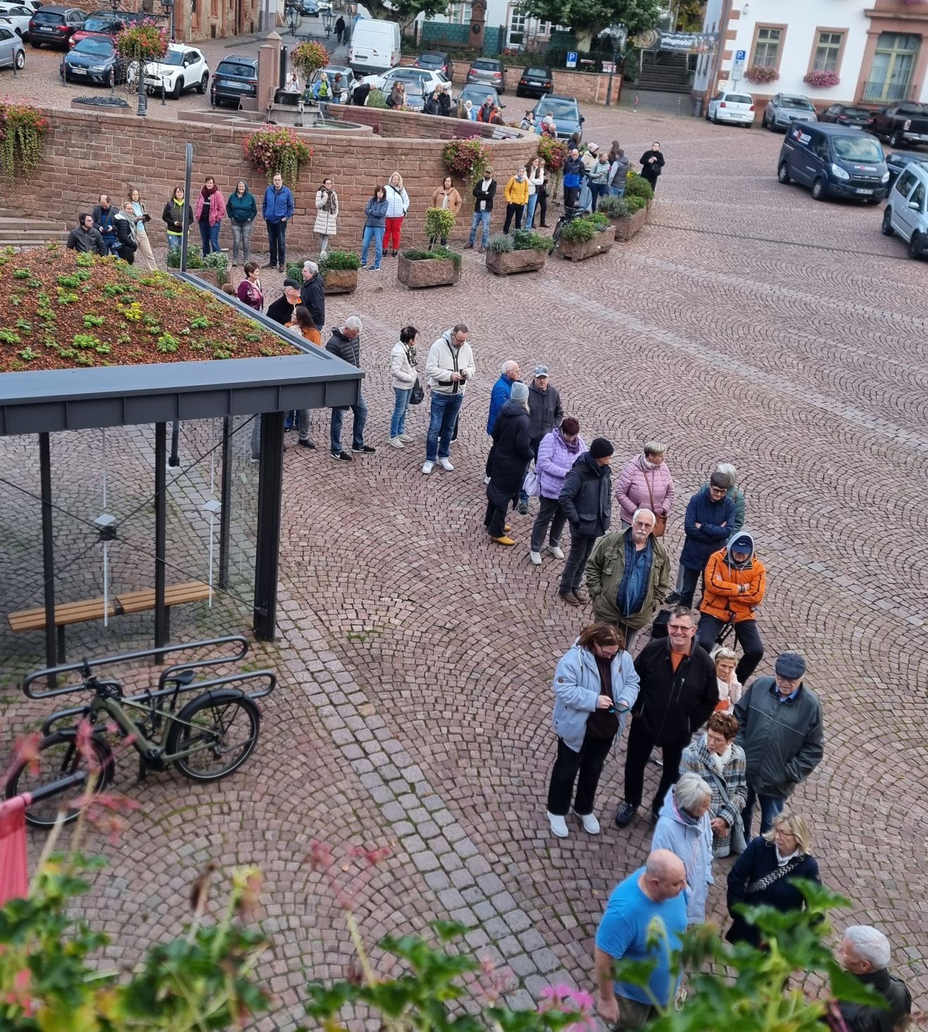Menschen stehen in einer langen Schlange auf dem Obermarkt vor der Tourist-Information.