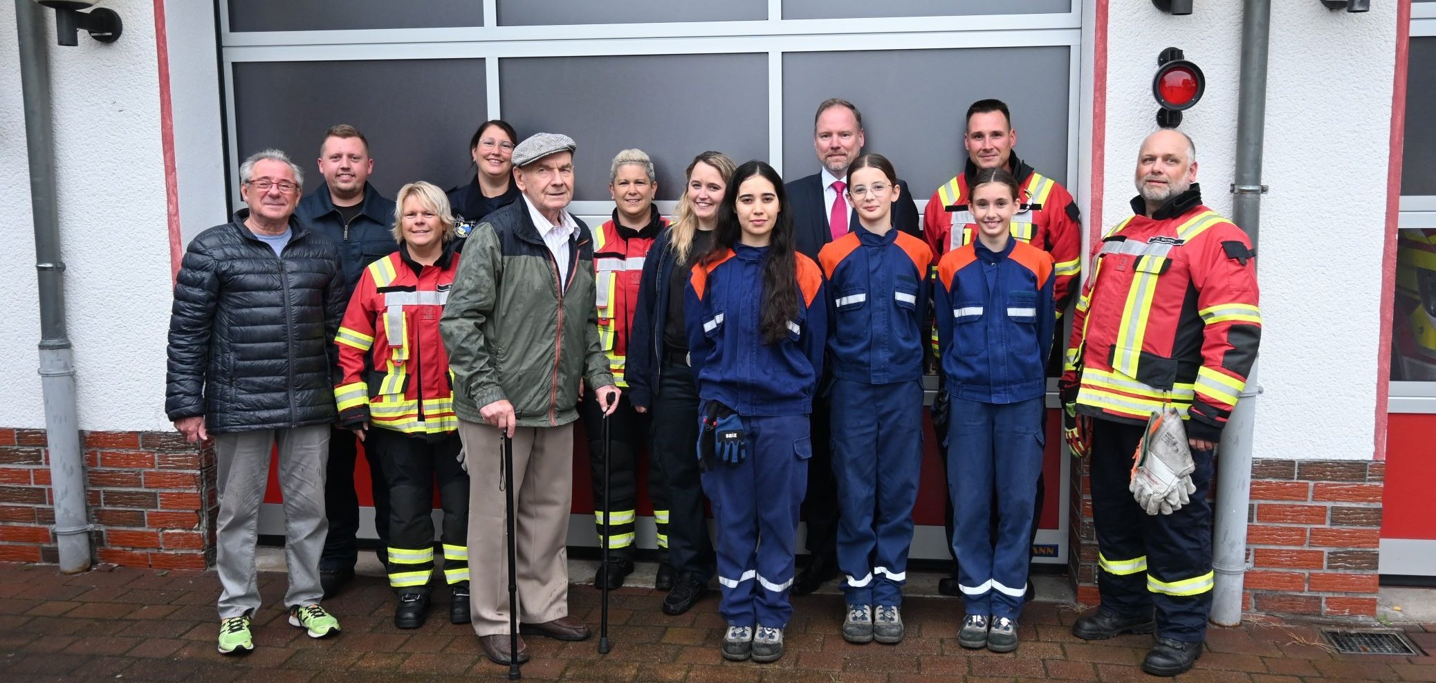 Bürgermeister Christian Litzinger, Röther Ortsvorsteher Ottmar Schüll, Erich Hofacker und die Kameradinnen und Kameraden der Freiwilligen Feuerwehr vor dem Feuerwehrstützpunkt Roth. 
