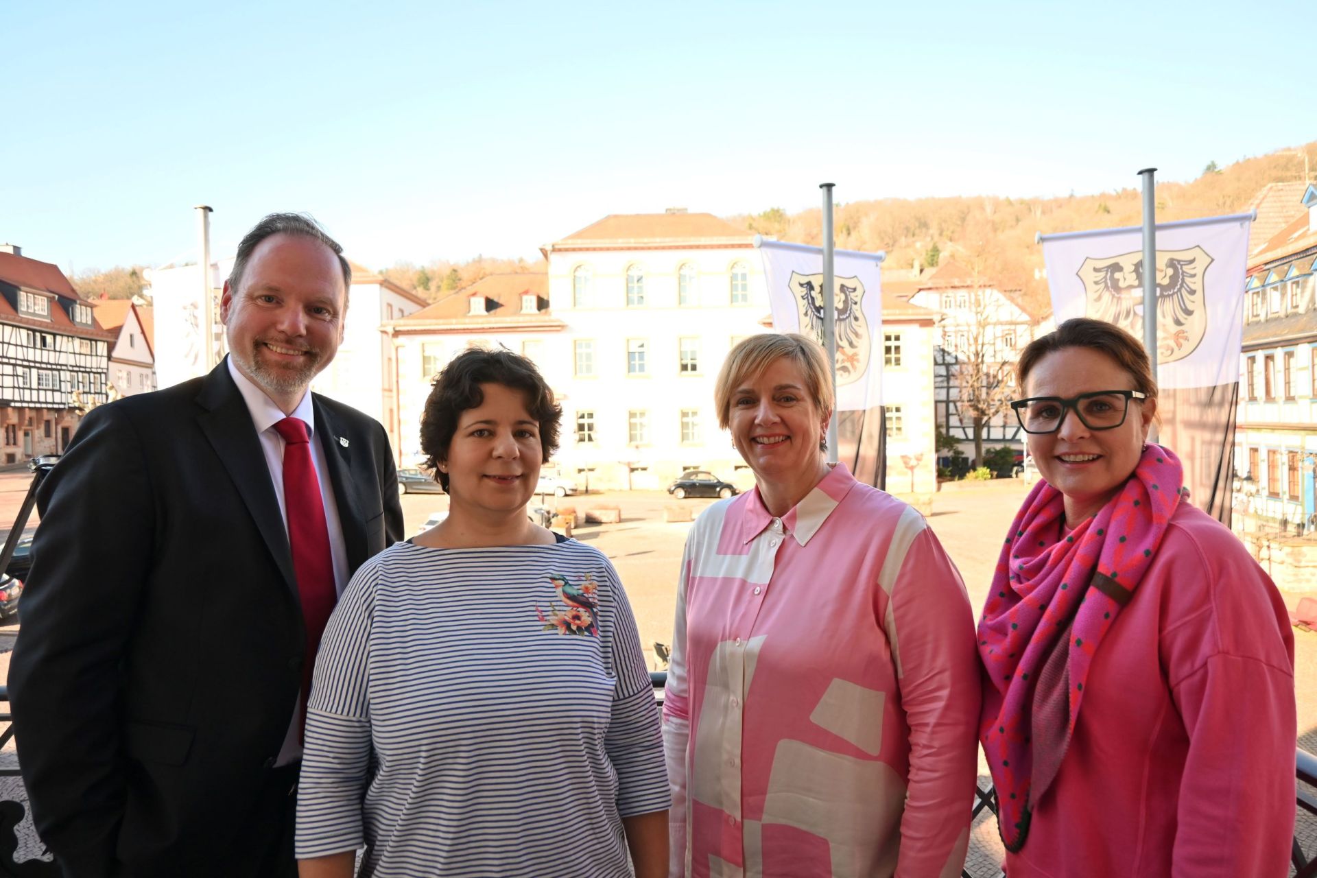 Bürgermeister Christian Litzinger, Cristina Oliva vom Förderverein Gelnhäuser Kindergärten e. V. und Birgit Malle und Bettina Büdel, beide vom Förderverein Barbarossakinder – Pro Kinderklinik Gelnhausen – e. V. auf dem Rathausbalkon mit dem Obermarkt im Hintergrund. 