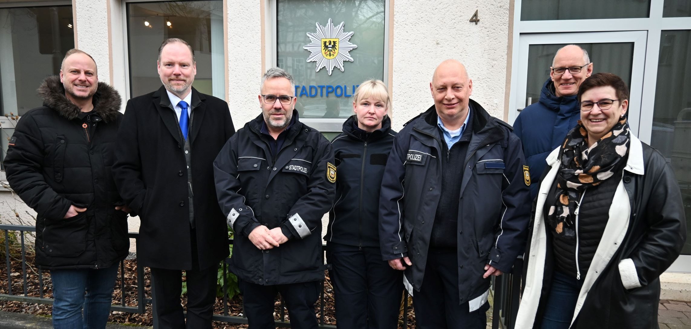 Bürgermeister Christian Litzinger und Mitarbeiterinnen und Mitarbeiter der Stadtverwaltung Gelnhausen sowie der Stadtpolizei Gelnhausen stehen vor den neuen Stationsräumen der Stadtpolizei. 
