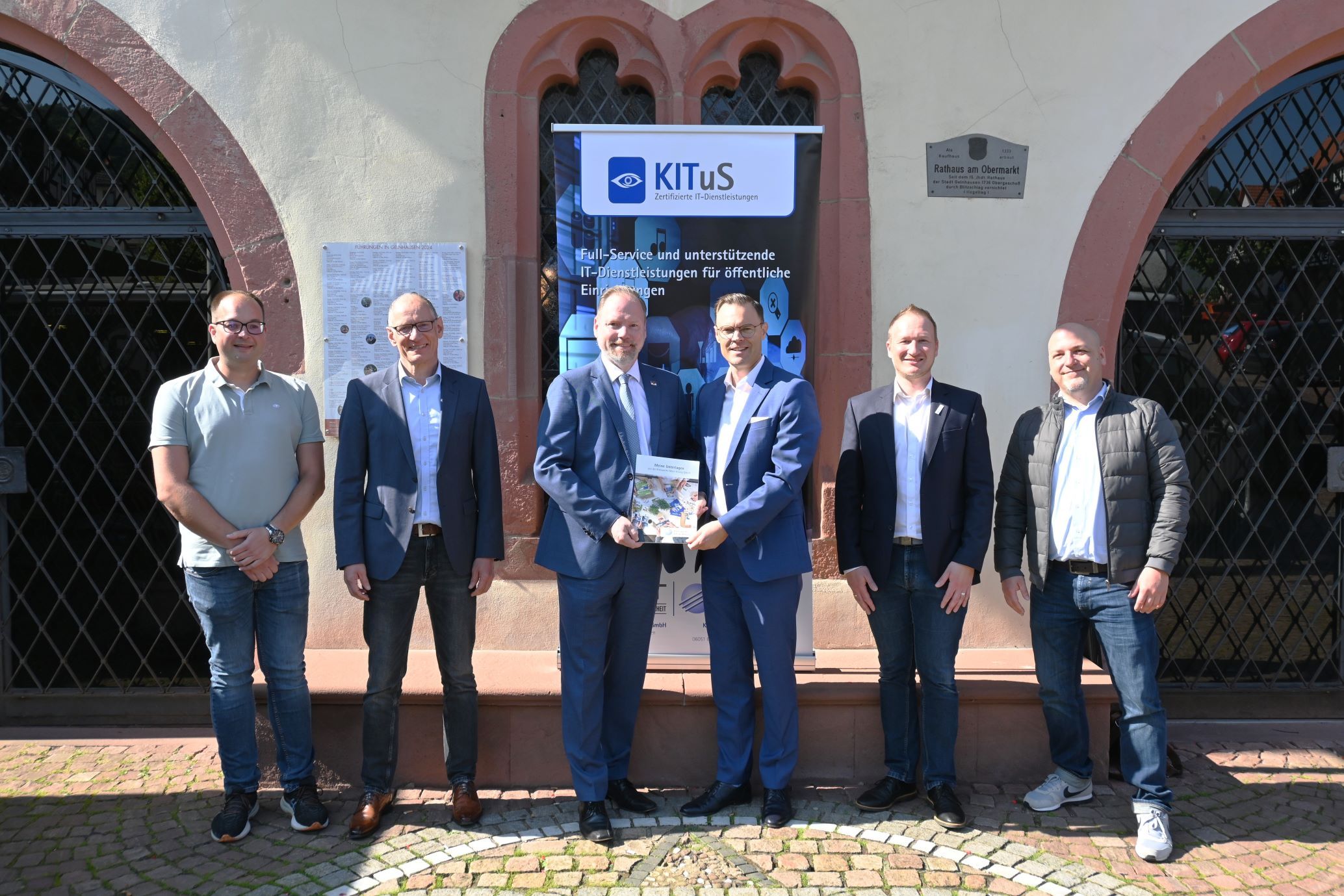 Vertreter von Stadt und Kreiswerke stehen vor dem Rathaus mit unterschriebenem Abnahmeprotokoll.