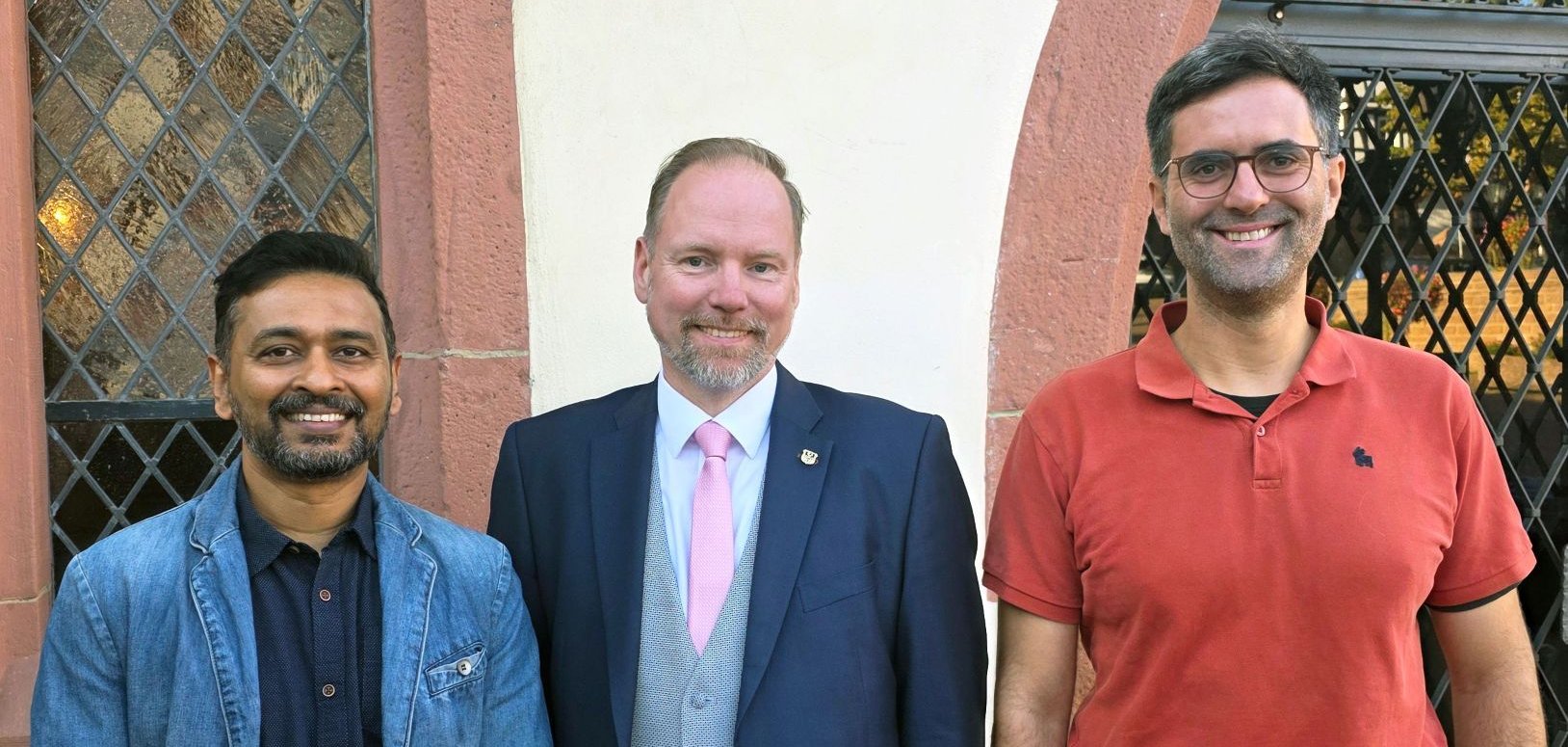 Bürgermeister Christian Litzinger, Projektleiter Rahul Ingle und Klimamanager Andreas Hlasseck stehen gemeinsam vor dem Rathaus in Gelnhausen. 