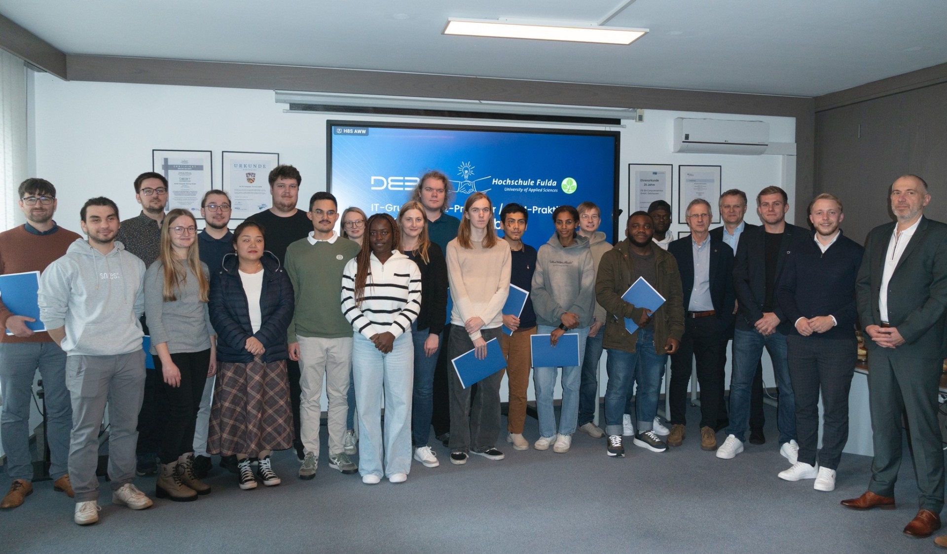 Eine Gruppe Menschen steht in einem Seminarraum. 