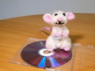 Plüschfigur Philipp Maus sitzt auf einer CD