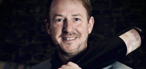 Abbildung des Autors, der sich eine Weinflasche über die Schulter legt